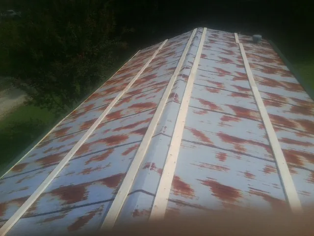 Rusted metal roof panels with new wood purlins before replacement — Storm Damage Roof Repair in Boaz by Roofing Brothers