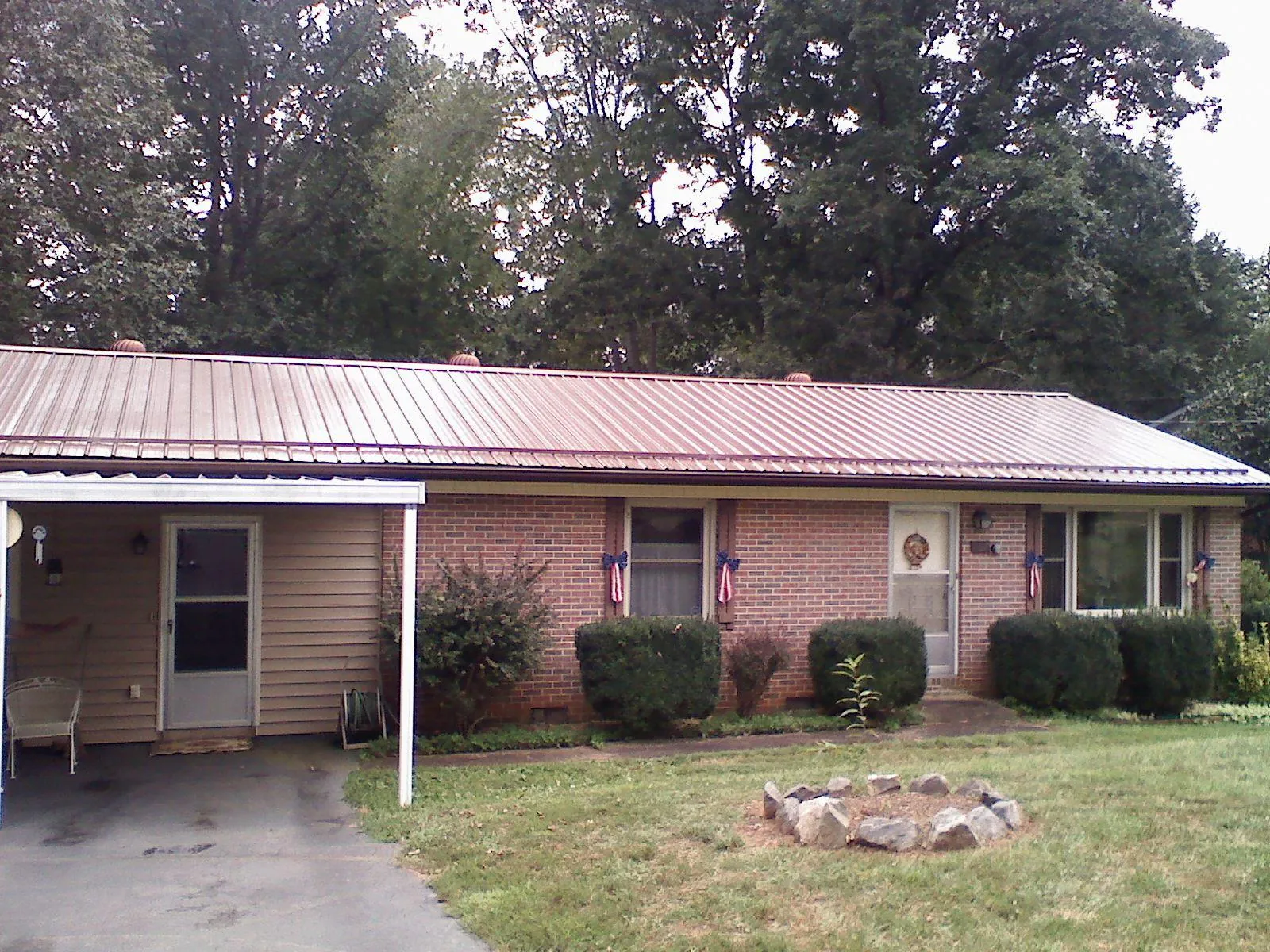 Bronze metal roof and carport on a brick ranch home — Roof Repair work by our crew in Boaz