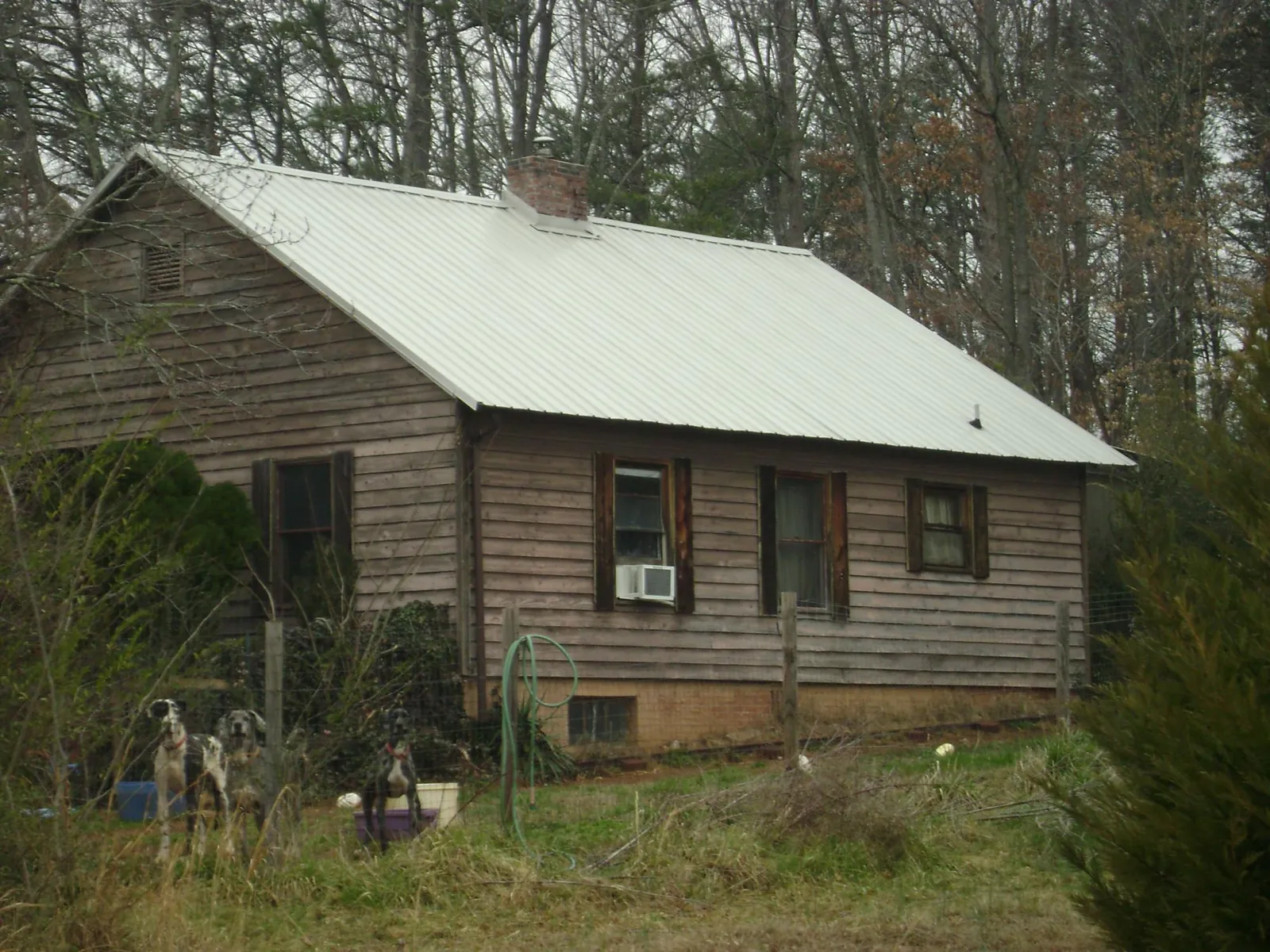 White metal roof on an old wood sided farmhouse, from a Metal Roof Installation job in Boaz
